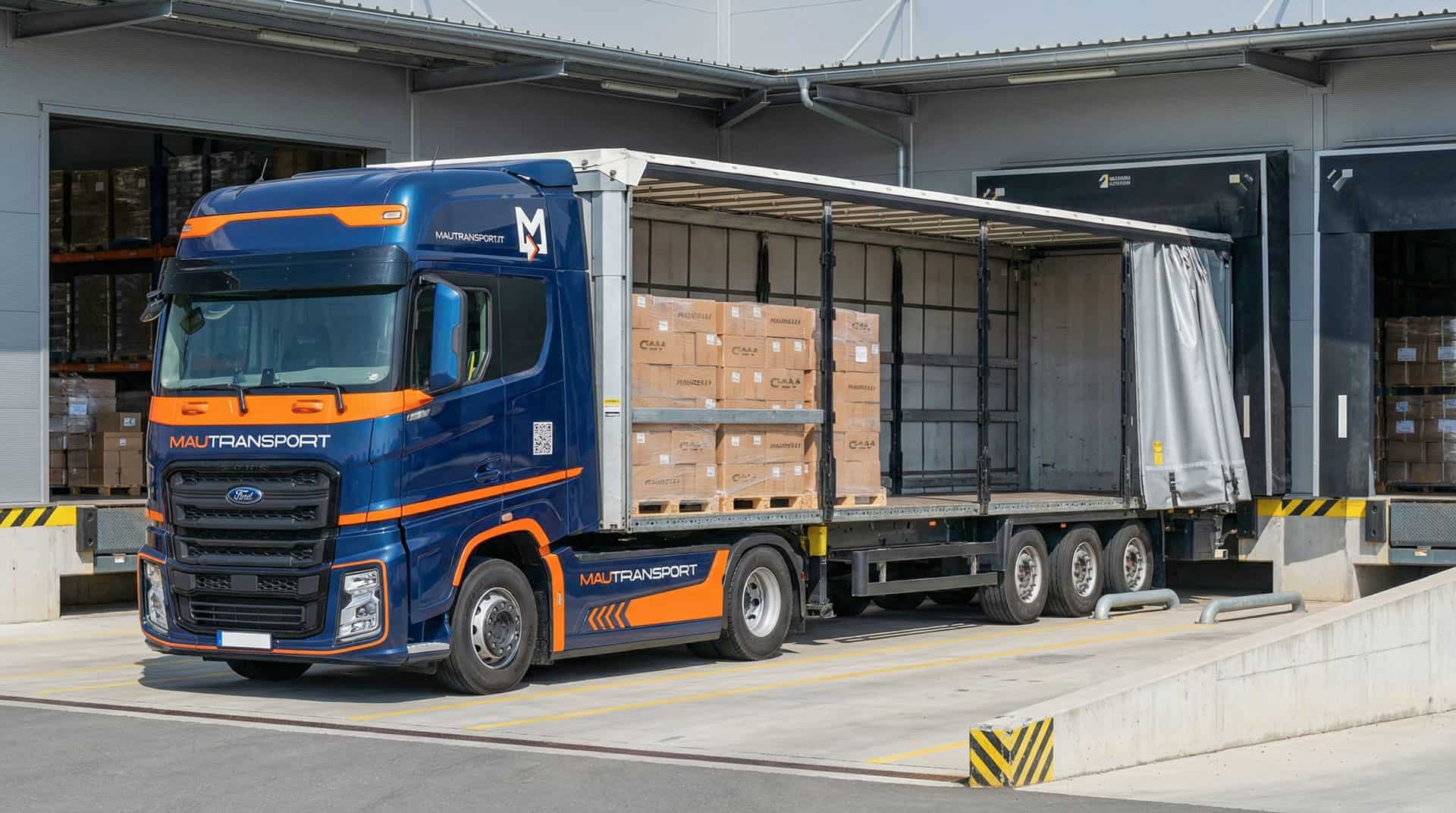 Veicolo industriale Ford Trucks Mautransport attraccato alla ribalta di un magazzino, con telone aperto e parziale carico di bancali Maurelli e GAM.
